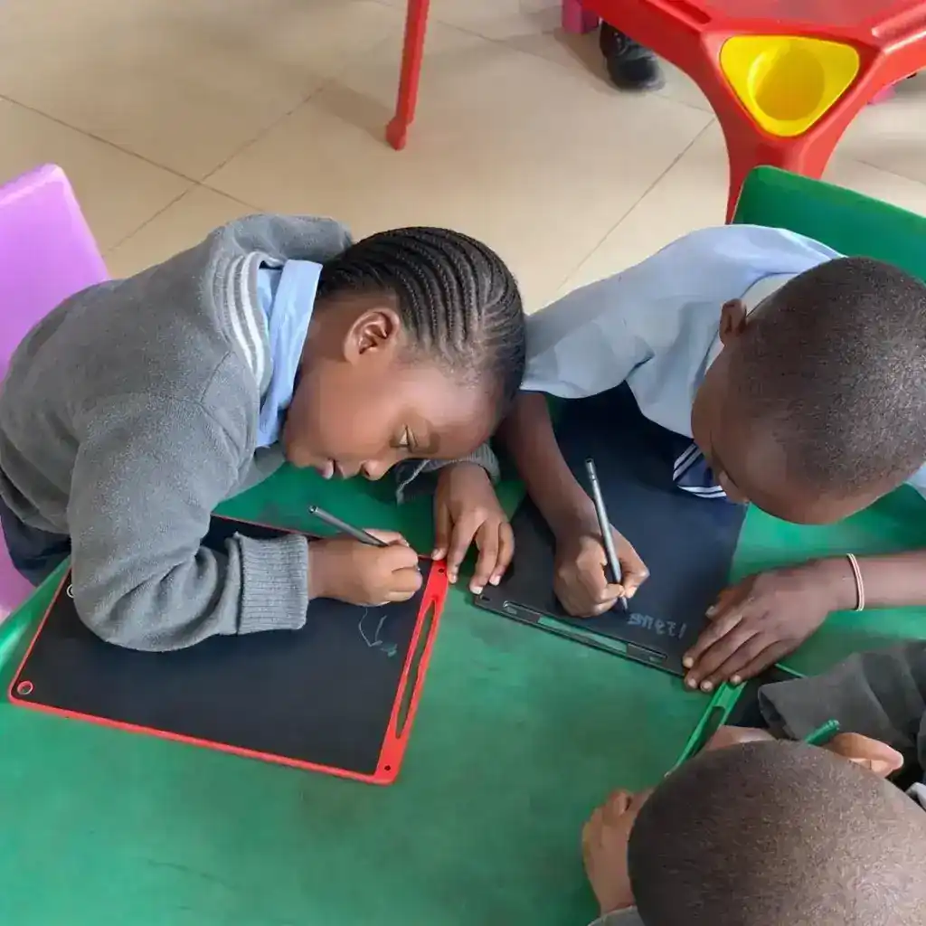 Children engaged in digital learning on computers at Sharell and Shalom Kids Centre